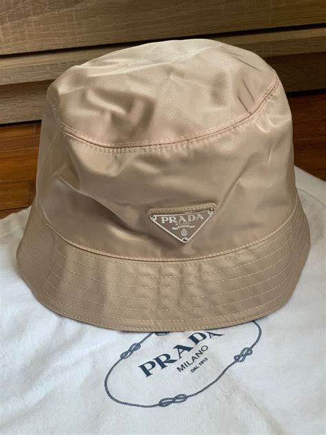 beige prada beanie|Prada black bucket hat.